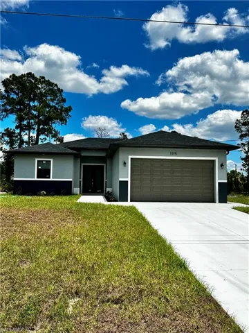 View of front of home featuring a garage and a front yard