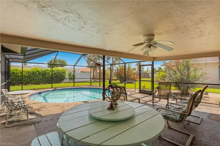 View of pool with a patio area, a lanai, ceiling fan, and a yard