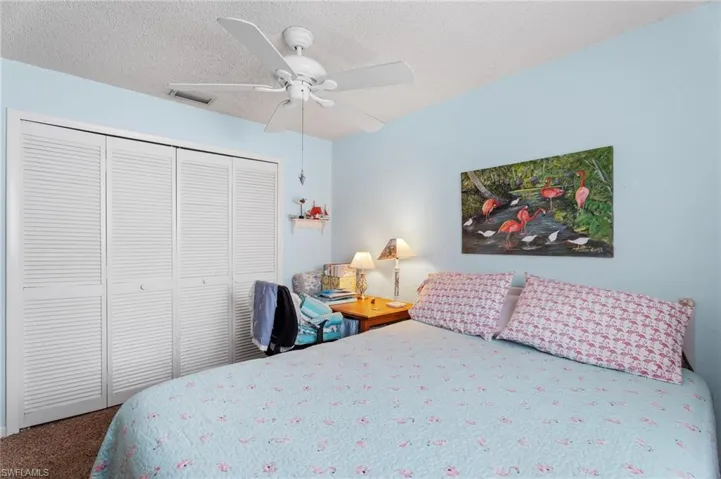 Bedroom featuring carpet flooring, a closet, a ceiling fan, and a textured ceiling