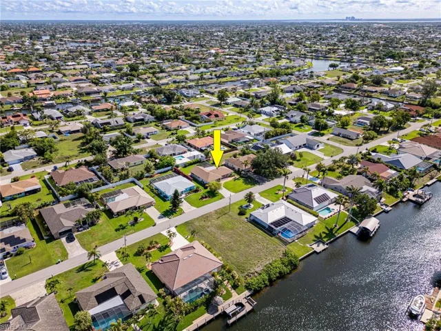 Aerial view of property's location featuring a large body of water and nearby suburban area