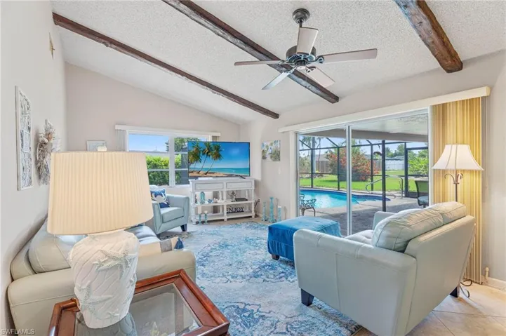 Living room featuring a textured ceiling, a ceiling fan, and plenty of natural light