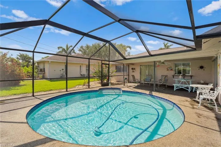 Outdoor pool featuring a patio area, ceiling fan, and a lanai