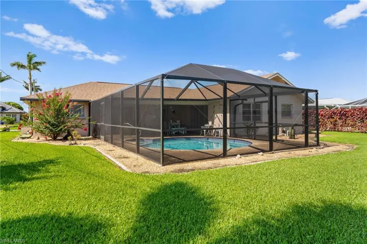 Back of house featuring a lawn, an outdoor pool, and a patio