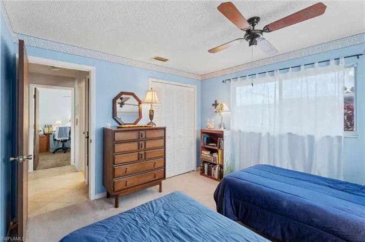 Bedroom featuring light carpet, a textured ceiling, a closet, and ceiling fan