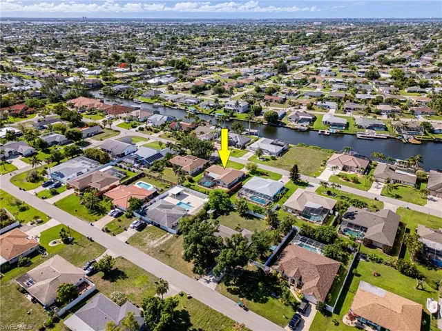 Aerial view of property and surrounding area featuring nearby suburban area and a large body of water