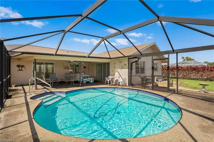 Outdoor pool featuring a patio area, a ceiling fan, and glass enclosure