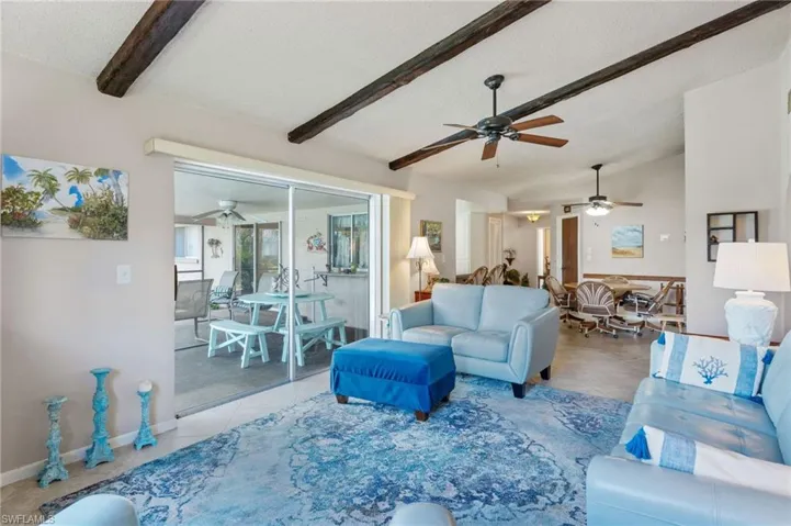 Living area featuring ceiling fan, tile patterned flooring, a textured ceiling, and baseboards