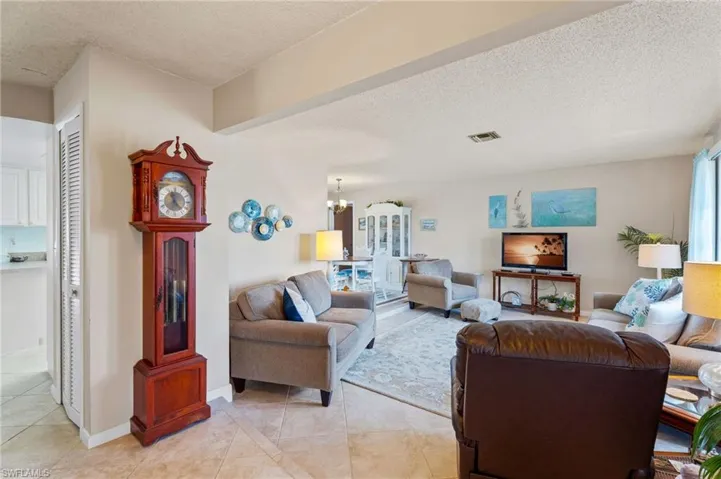Living room featuring a textured ceiling, light tile patterned flooring, and a chandelier