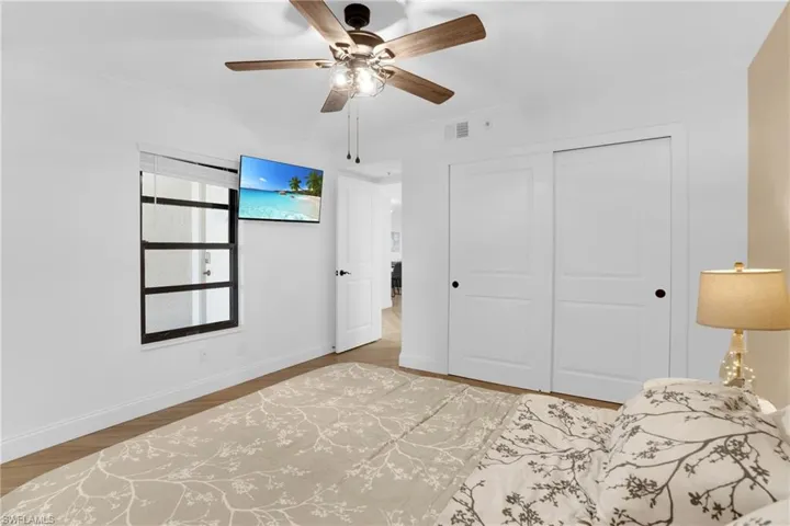 Bedroom with crown molding, ceiling fan, a closet, and light wood-type flooring