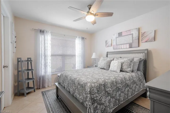 Additional guest bedroom featuring ceiling fan and neutral tile flooring