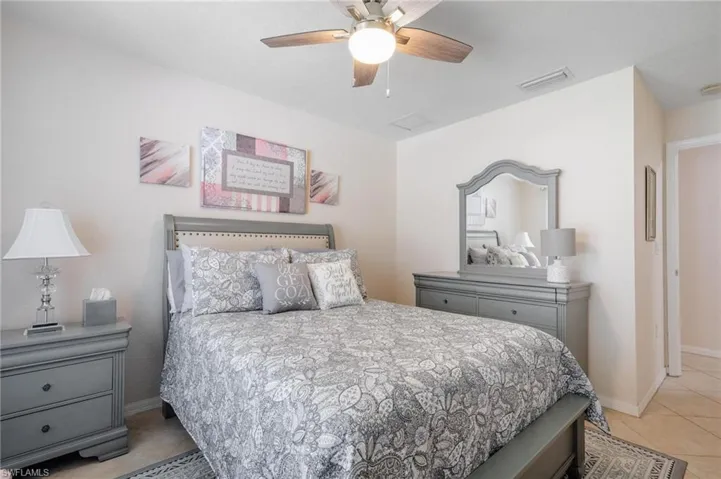 Additional guest bedroom, featuring ceiling fan and neutral tile flooring