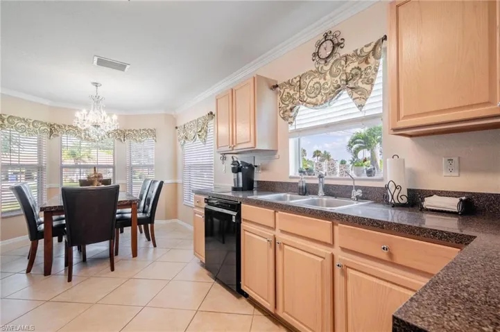 Kitchen featuring dishwasher, sink, a wealth of natural light, and light tile floors