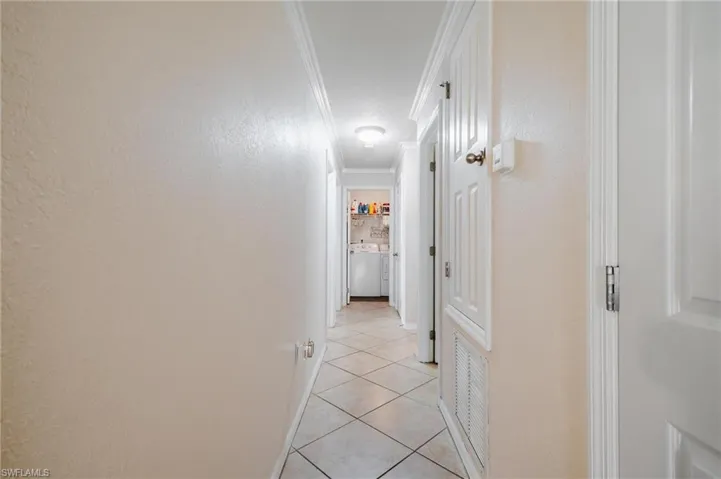 Hall featuring crown molding and neutral tile floors
