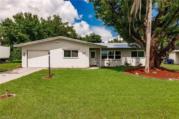 Ranch-style home featuring a garage and a front yard