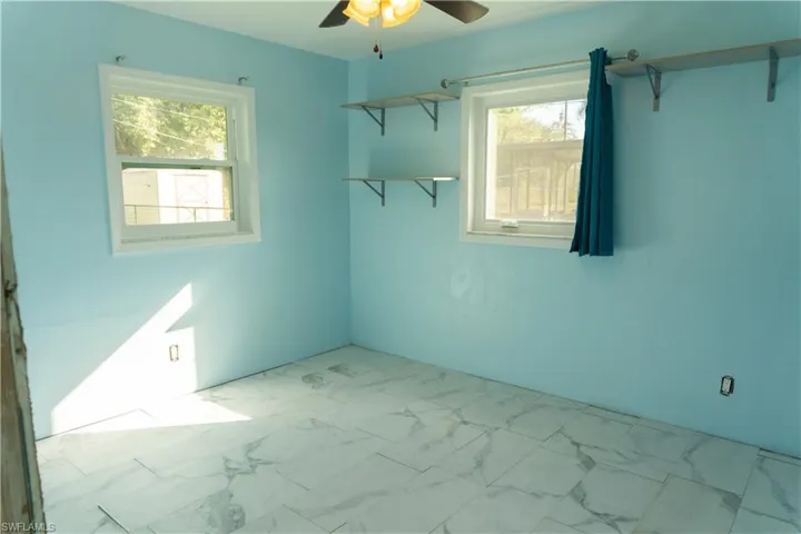 Spare room featuring a wealth of natural light and ceiling fan