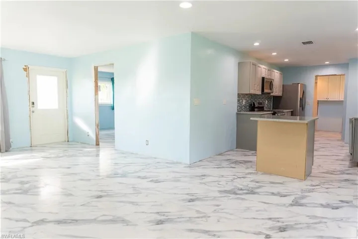 Kitchen with stainless steel appliances and tasteful backsplash