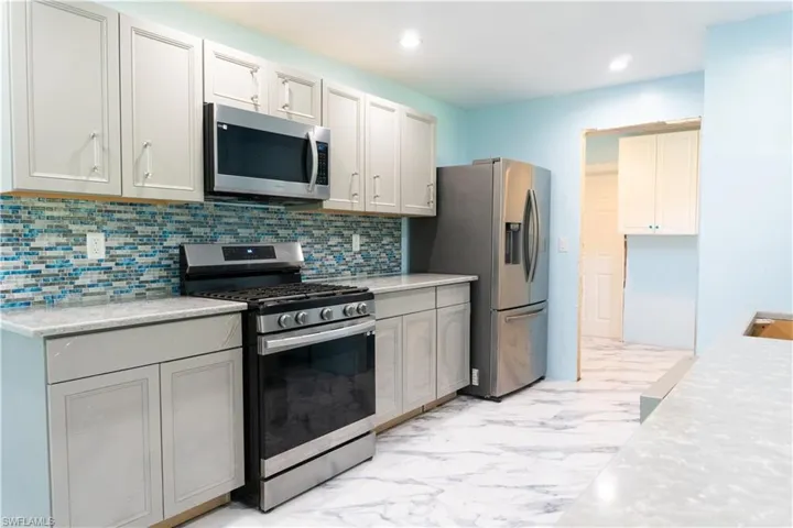 Kitchen featuring stainless steel appliances and tasteful backsplash