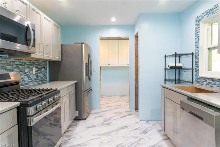 Kitchen featuring backsplash, sink, and stainless steel appliances