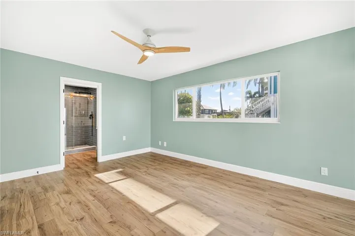 Unfurnished room with wood finished floors and a ceiling fan