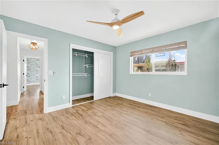 Unfurnished bedroom featuring wood finished floors, a closet, and a ceiling fan