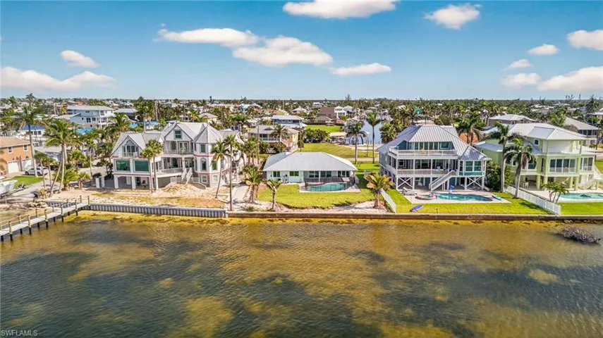 Aerial perspective of suburban area featuring a nearby body of water