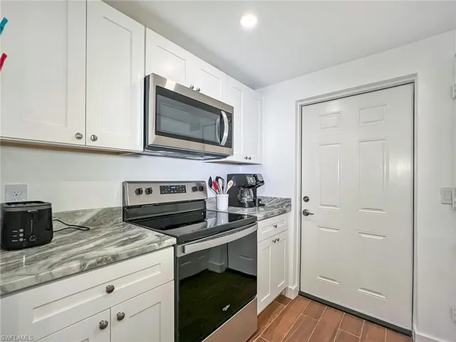 Kitchen featuring New Granite counters, stainless steel appliances, and white cabinets with soft close doors
