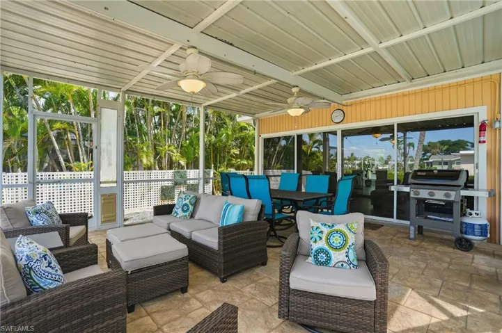 View of patio featuring outdoor lounge area, a ceiling fan, outdoor dining area, grilling area- Virtually Edited Image