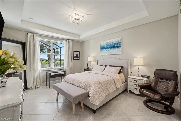 Tray ceiling with recessed lighting and a central geometric light fixture