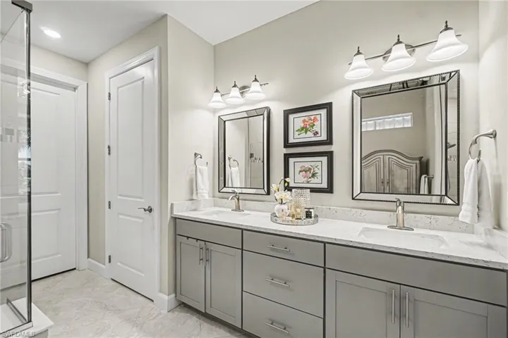 Double vanity with gray cabinetry, white countertops, and undermount sinks
