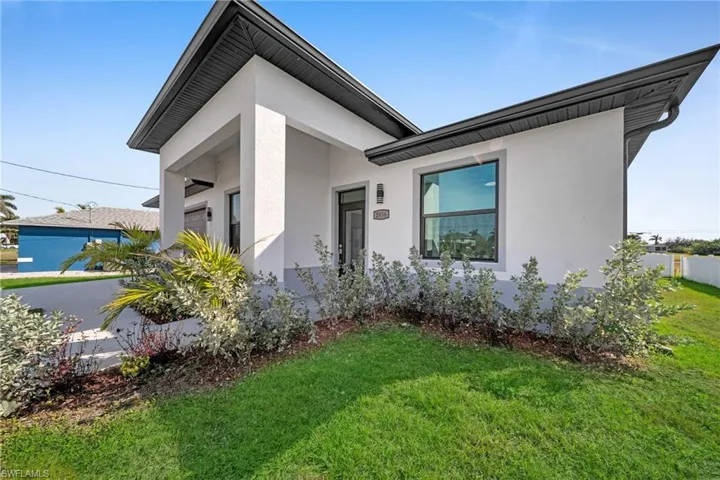 View of front of home with stucco siding and a front lawn