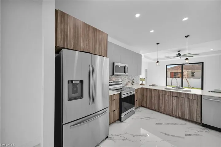 Kitchen with stainless steel appliances, a sink, modern cabinets, recessed lighting, and tasteful backsplash
