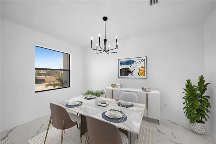 Dining room featuring light marble finish floors, a chandelier, and baseboards