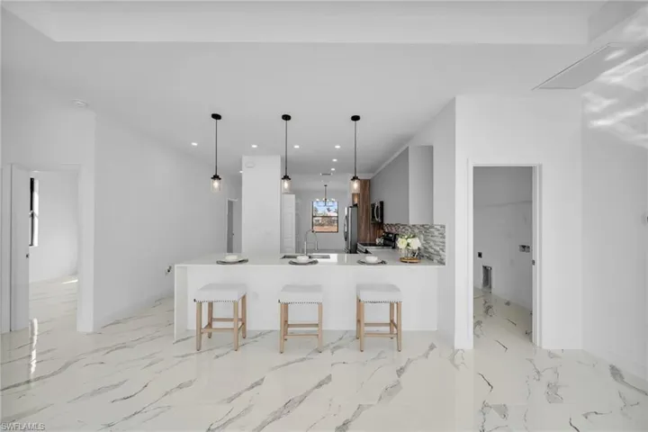 Kitchen with stainless steel appliances, a breakfast bar, a sink, recessed lighting, and a peninsula