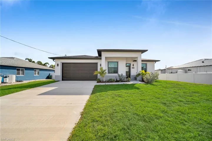 View of front facade with stucco siding, a garage, and concrete driveway
