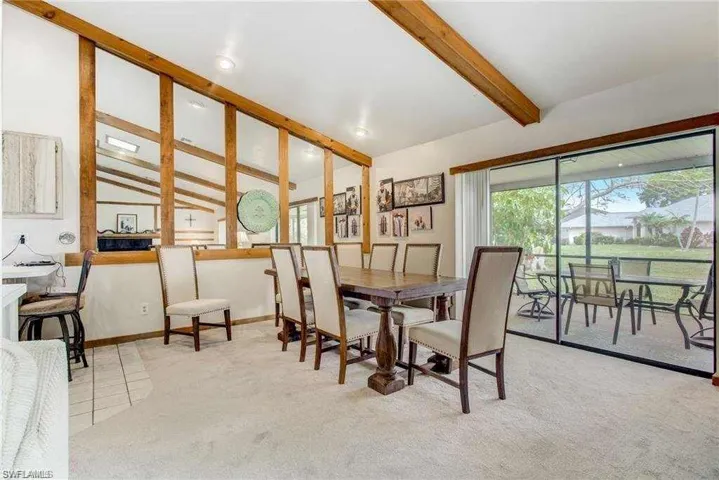 Dining room featuring light carpet and lofted ceiling with beams