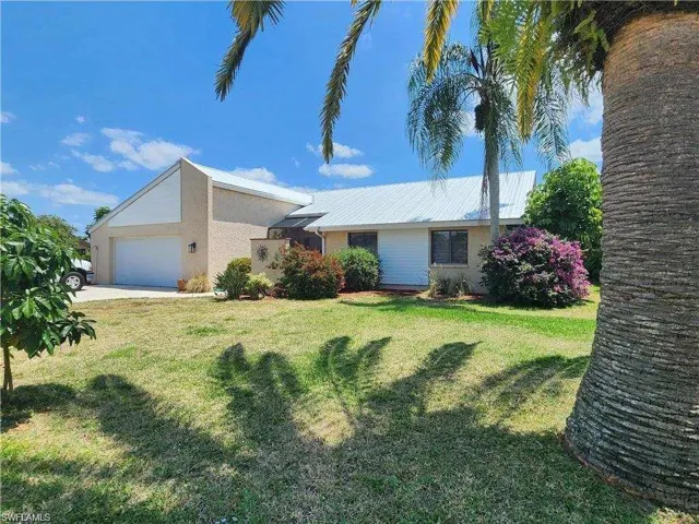 Single story home with a garage and a front yard