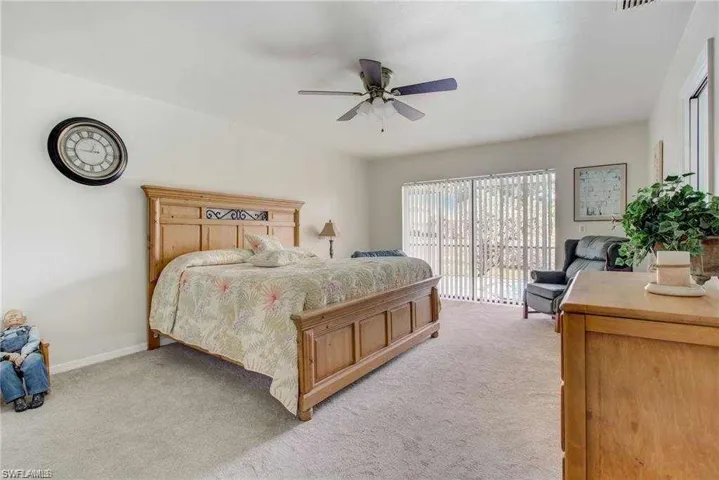 Carpeted bedroom with access to exterior and ceiling fan