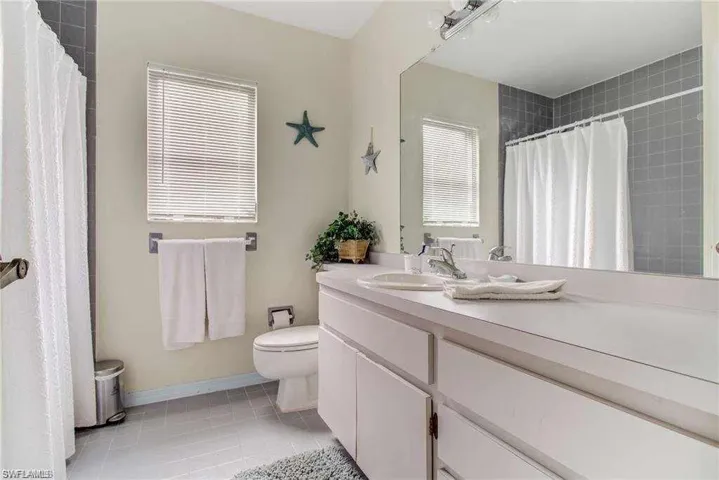 Bathroom featuring tile patterned flooring, vanity, and toilet