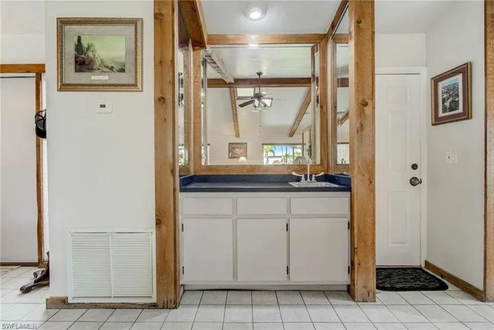 Bathroom with tile patterned floors, ceiling fan, vanity, and lofted ceiling with beams