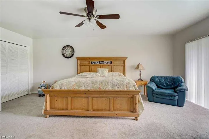 Carpeted bedroom featuring a closet and ceiling fan