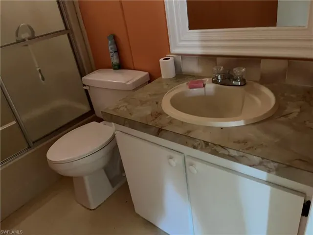 Full bathroom with vanity and bath / shower combo with glass door