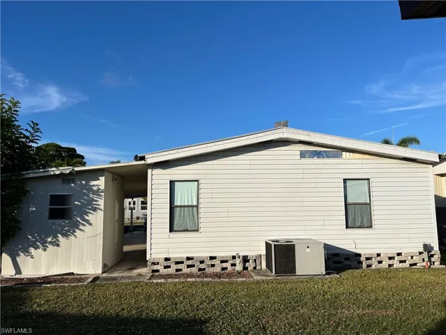 View of side of property with a lawn and a central air condition unit