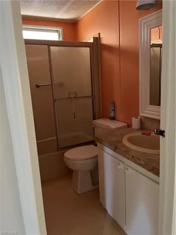 Full bathroom featuring vanity and a shower with door