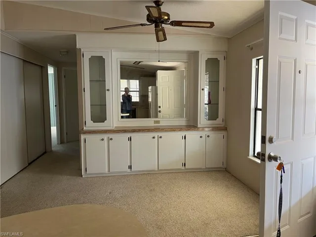 Bathroom with vanity, light carpet, a ceiling fan, and ornamental molding
