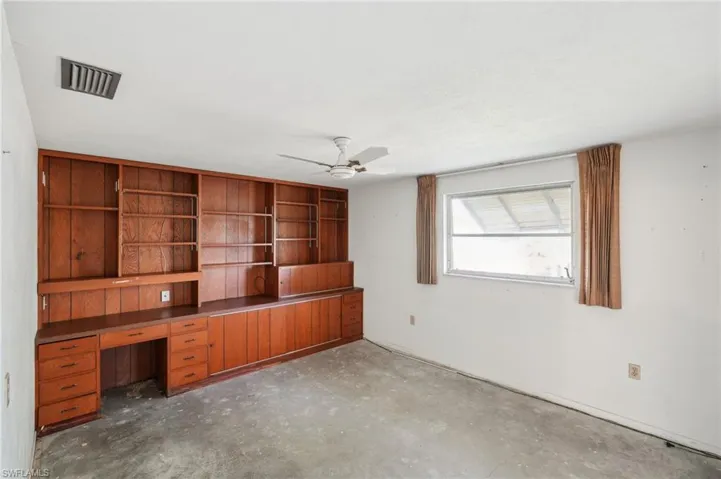 Unfurnished office with ceiling fan and concrete flooring