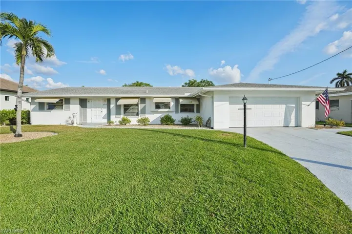 Ranch-style home with a garage and a front lawn