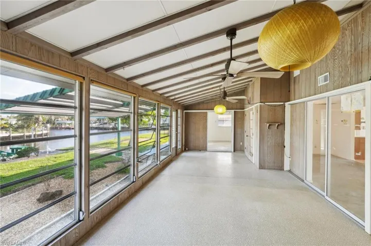 Sunroom with lofted ceiling with beams and a water view