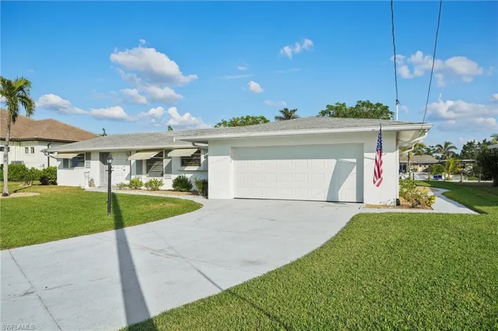 Ranch-style home with a garage and a front lawn