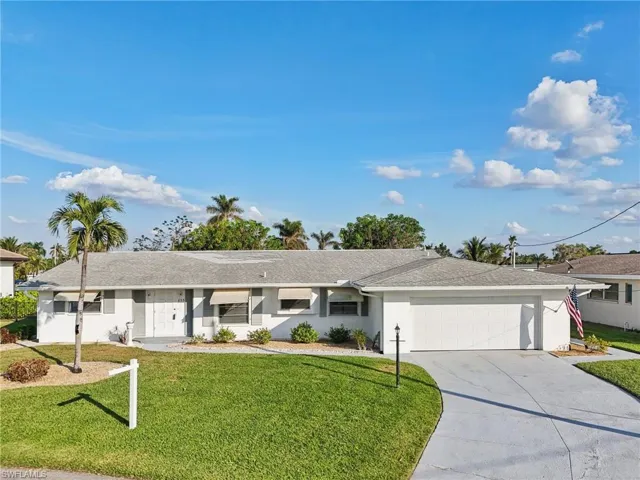 Ranch-style home with a front yard and a garage