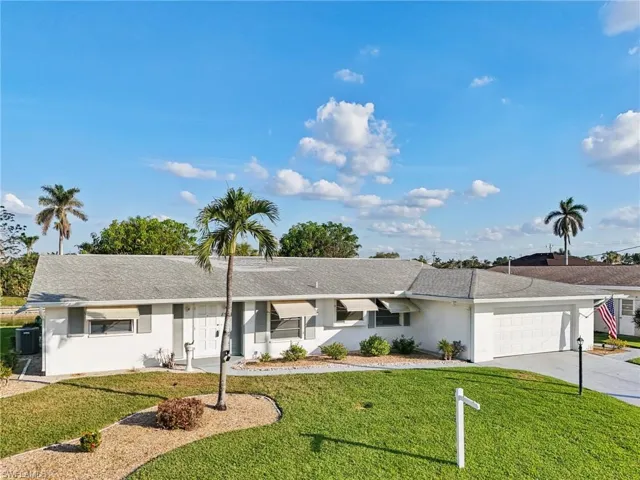 Ranch-style house with a front lawn and a garage